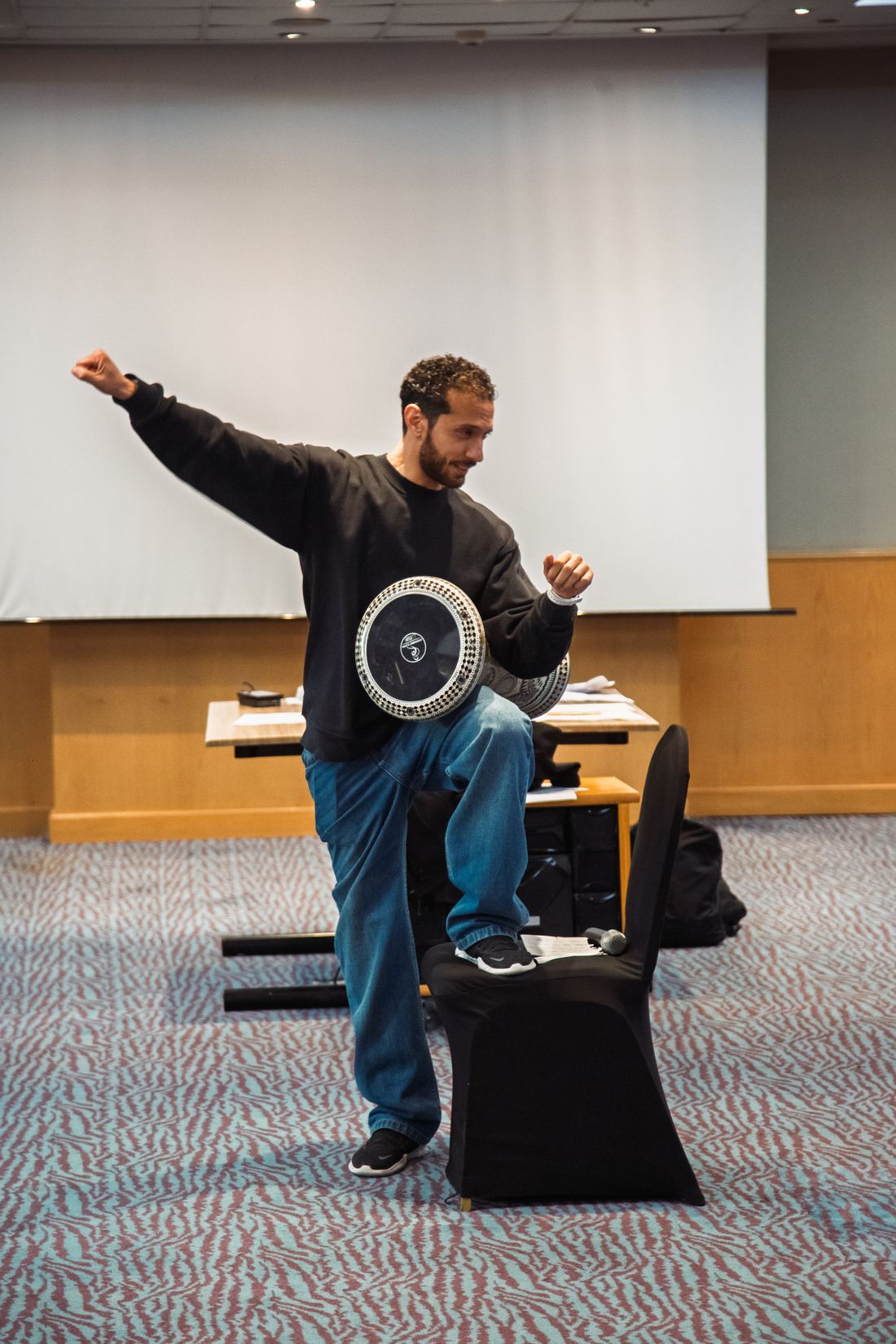 A facilitator playing a traditional Arabian drum