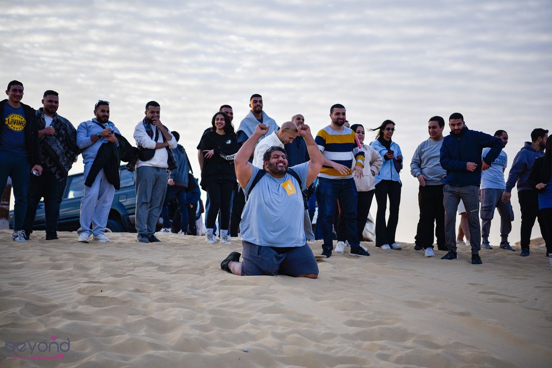 A participant celebrating a winning performance surrounded by the team